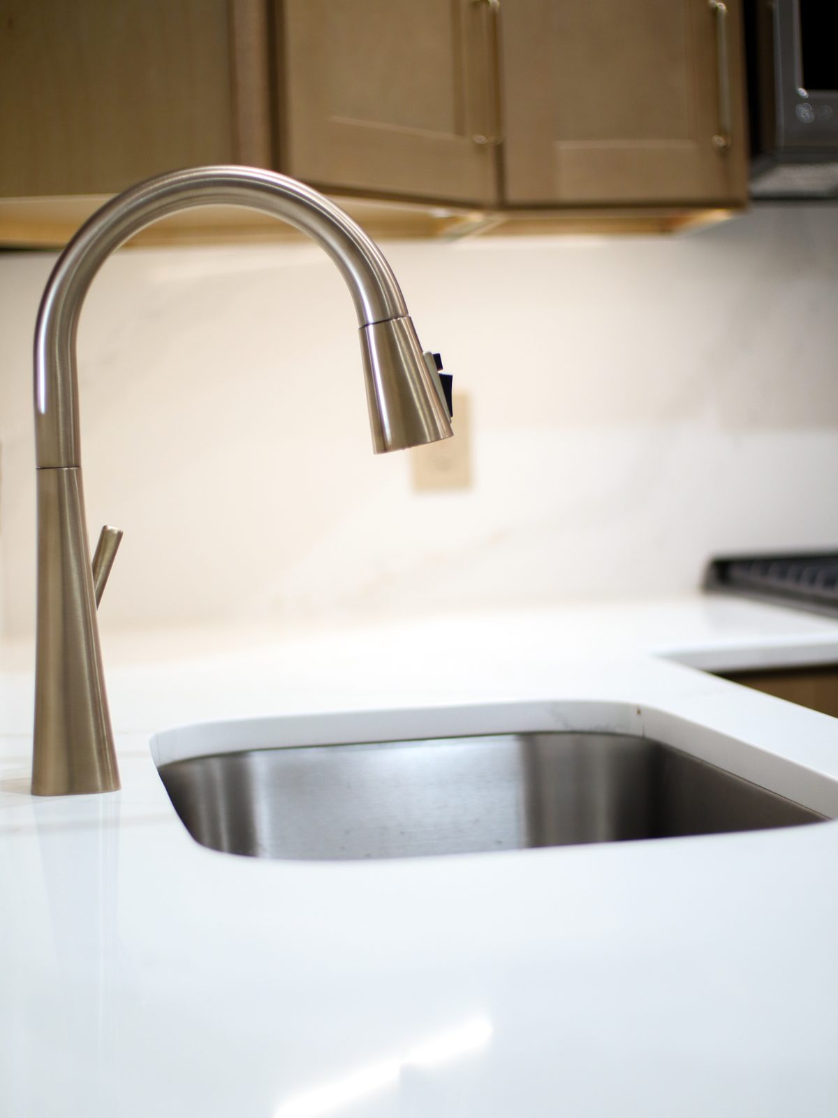 Close-up of the gold pull-down kitchen faucet