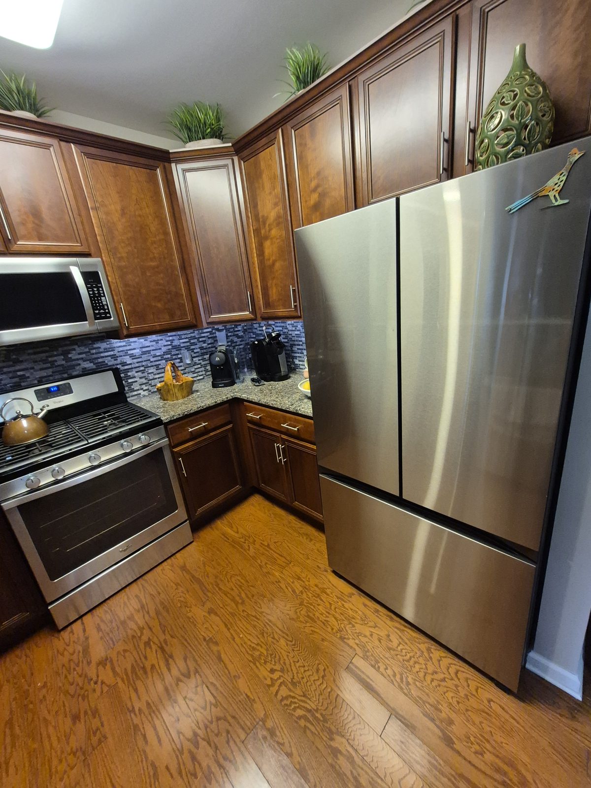 The Cherry Hill kitchen before the remodel, dark cabinets, granite counters and a glass tile backsplash